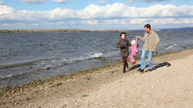 family running on bank of river