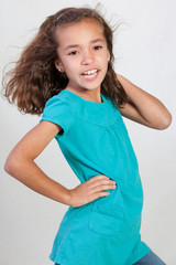 Cute Hispanic young girl wearing a teal shirt