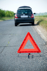 Broken down car with red warning triangle