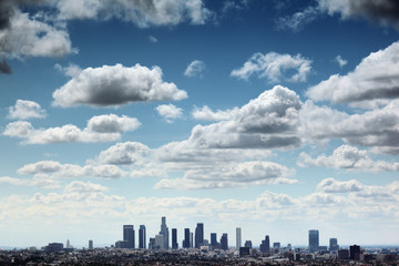 Downtown Los Angeles skyline under blue sky with scenic clouds