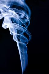 Fototapeta premium Stream of a blue smoke on a black background