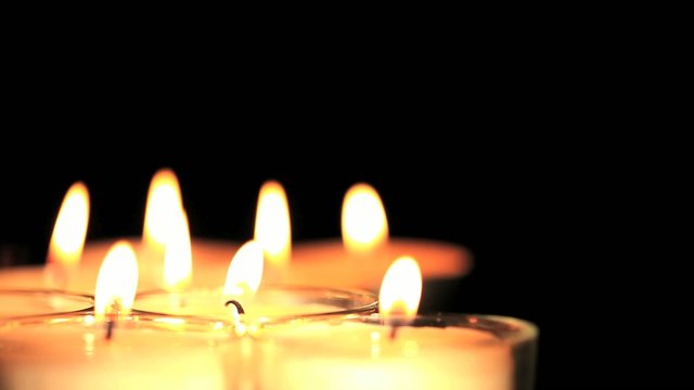 White candles on black background focused
