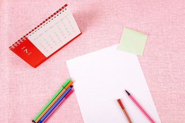 Clutter of objects stacked on pink background