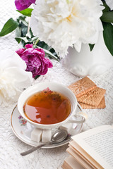 Tea with cookies, the book and flowers