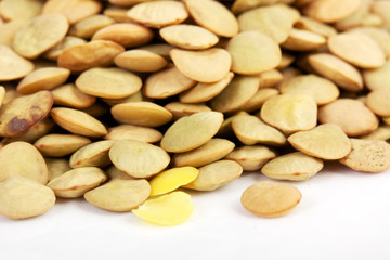 Lentil scattered on white background close up view