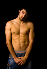Obraz premium Young man with atletic body on black background