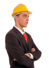 Pensive young engineer with a yellow helmet on white background