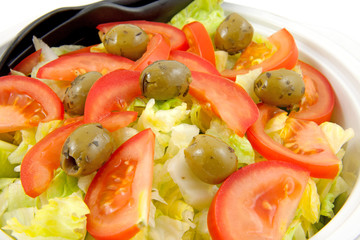 bowl with fresh salad over white background