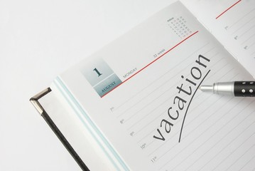 Appointment book with pen and vacation text