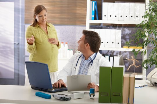 Pregnant woman consulting with doctor.