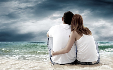 Fototapeta premium Sea view of a couple sitting on beach.