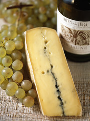 morceau de morbier, vin du jura et grappe de raisin 