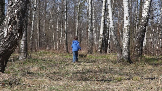 boy runs to spring brich grove from camera