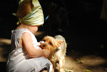 baby girl in a white dress with a small dog - obrazy, fototapety, plakaty
