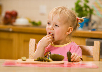 little girl eating cucumber