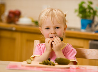 little girl eating cucumber