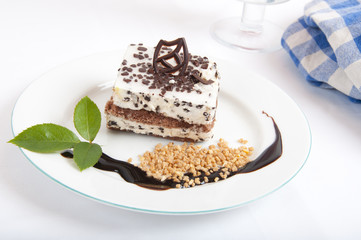 Sweet chocolate dessert with nuts and chocolate on white plate
