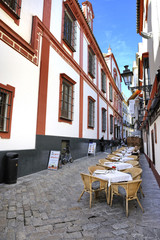 Fototapeta na wymiar Brukowanej nawierzchni ulicy z restauracji w Sewilli