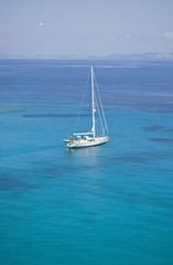 white sailing boat on turquoise ionian sea