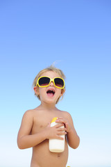 child with sunglasses holding suncream © mangostock