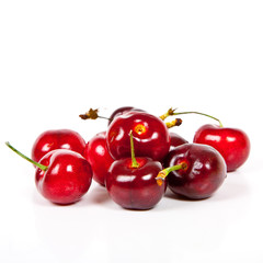 Fresh ripened red cherries over white background
