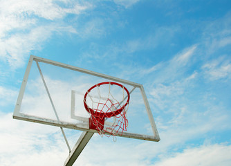 Outdoor basketball hoop over blue sky