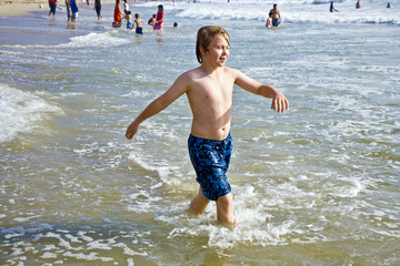 boy plays at the beautiful beach in California