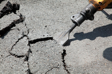 Breaking asphalt with pneumatic hammer - jackhammer