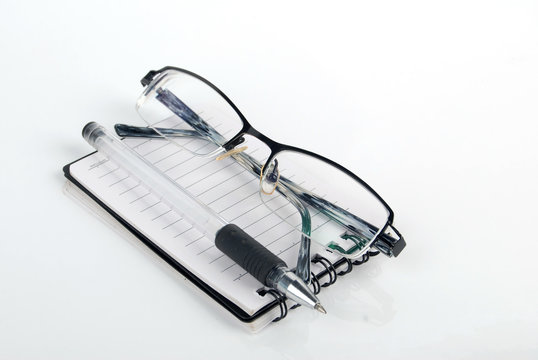 glasses,pen with notebook