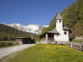 kleine kirche und blockhütten in den tiroler alpen