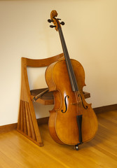 Cello or violincello, resting on chair with bow