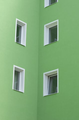 Row of windows on green wall of house