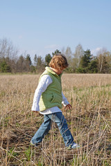 Trzyletnia dziewczynka idzie po polu