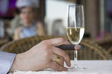 Man in cafe drinking wine and smoking cigar