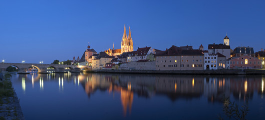 Panorama der Altstadt Regensburg mit Dom und Steinerne Brücke zur blauen Stunde bei Nacht