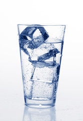 glass with cold mineral water, bubbles and ice