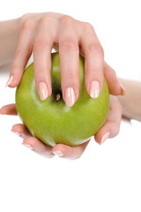 Green apple in a beautiful hand of woman with perfect nail manic