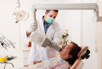 A dentist takes a x-ray on an Asian patient