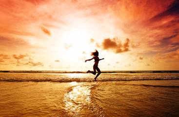 Fototapeta na wymiar The girl jumping on a tropical beach
