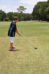 Fototapeta premium young boy driving a golf ball