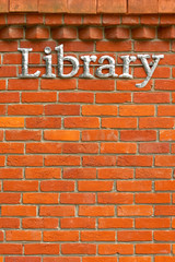metal library sign on a brick wall background