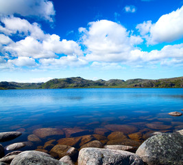 Blue lake idill under cloudy sky