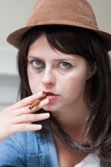 Fototapeta premium Young junkie woman smoking a cigar