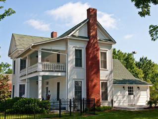Fototapeta na wymiar Old White Two Story Farmhouse with Red Brick Chimney