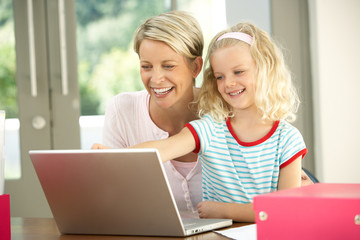 Mother And Daughter Using Laptop At Home