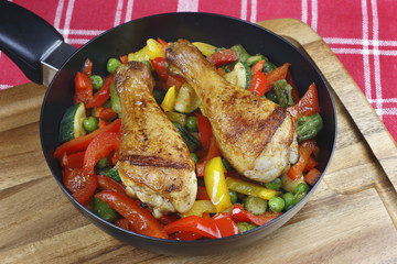 Chicken legs with fried vegetables