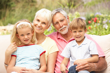 Fototapeta premium Grandparents And Grandchildren Relaxing In Garden