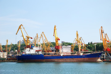 The trading seaport with cranes, cargoes and ship