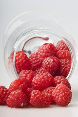 raspberries spilled from a glass