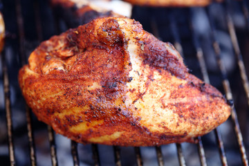 Barbecue chicken breast on grill closeup cooking
